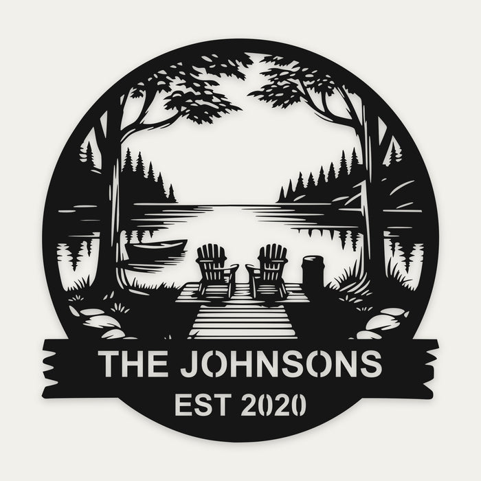 Lakeside dock personalized cottage sign in black steel with two chairs, pines and THE JOHNSONS EST 2020 on the banner